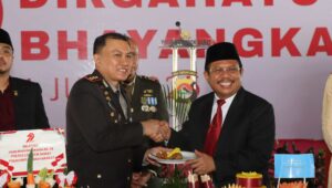 Lombok Barat, NTB – Kepolisian Republik Indonesia (Polri) merayakan ulang tahunnya yang ke-79 pada 1 Juli 2025. Di Lombok Barat, peringatan Hari Bhayangkara kali ini selain dengan menggelar upacara, juga ditandai dengan acara tasyakuran yang penuh makna. Menegaskan kembali komitmen Polri untuk terus meningkatkan kualitas pelayanan kepada masyarakat. Pada Selasa (1/7/2025), suasana di bencingah kantor Bupati Lombok Barat tampak semarak dengan kehadiran para pejabat dan tokoh masyarakat. Acara Tasyakuran Hari Bhayangkara ke-79 ini digelar di Jalan Soekarno-Hatta, Kelurahan Dasan Geres, Kecamatan Gerung, Kabupaten Lombok Barat, menjadi momentum penting. Untuk mempererat sinergitas antara Polri, TNI, pemerintah daerah, dan seluruh elemen masyarakat. Meningkatkan Pelayanan dan Memperkuat Sinergi Dalam sambutannya yang penuh semangat, Kapolres Lombok Barat, AKBP Yasmara Harahap, S.I.K., menyampaikan bahwa Hari Bhayangkara ke-79 mengusung tema ‘Polri untuk Masyarakat’. Menurutnya, tema ini bukan sekadar slogan, melainkan sebuah amanah untuk terus berbenah. "Dalam rangka Hari Bhayangkara ke-79 tahun 2025 dengan tema Polri Untuk Masyarakat, tentunya kita harus meningkatkan kualitas diri sebagai insan Bhayangkara. Untuk melaksanakan pelayanan maksimal kepada masyarakat," ujar AKBP Yasmara. Ia menekankan pentingnya introspeksi diri dan peningkatan kinerja untuk memberikan pelayanan terbaik. "Polri tegak berdiri dan berkomitmen untuk menjadi lebih modern dan terpercaya," tambahnya. Menurut Kapolres, semua upaya ini bertujuan utama untuk menjaga stabilitas keamanan dan ketertiban masyarakat (kamtibmas) di Provinsi NTB agar tetap kondusif. Ia juga menjelaskan bahwa rangkaian kegiatan dalam rangka Hari Bhayangkara di Polres Lombok Barat sudah dimulai sejak awal Juni. Dengan berbagai kegiatan yang menyentuh langsung masyarakat. AKBP Yasmara Harahap juga menyampaikan rasa terima kasihnya kepada semua pihak yang telah mendukung tugas-tugas Polri. "Terima kasih kepada Bapak Bupati yang telah mendukung tugas-tugas kamtibmas. Tidak mungkin kami berjalan sendiri tanpa dukungan dari Pemda dan seluruh elemen masyarakat," tegasnya. Kolaborasi Pemerintah dan Polri untuk Pelayanan Optimal Senada dengan Kapolres, Bupati Lombok Barat, H. Lalu Ahmad Zaini, S. Si., M.T., juga memberikan apresiasi setinggi-tingginya kepada jajaran kepolisian. Dalam pernyataannya, Bupati mengucapkan selamat Hari Bhayangkara dan menekankan pentingnya sinergi antara pemerintah daerah dan Polri. "Atas nama Pemerintah Kabupaten Lombok Barat, kami menyampaikan dirgahayu Kepolisian," kata Bupati Lalu Ahmad Zaini. "Sinergitas dan kolaborasi akan terus kita tingkatkan agar pelayanan kepada masyarakat akan terus dapat dioptimalkan,” imbuhnya. Pernyataan ini menunjukkan komitmen kuat dari pemerintah daerah untuk terus bekerja sama dengan Polri demi kesejahteraan dan keamanan masyarakat Lombok Barat. Momen Kebersamaan dan Apresiasi Setelah sambutan, acara dilanjutkan dengan momen simbolis pemotongan kue dan tumpeng. Kapolres Lombok Barat bersama Ibu Ketua Bhayangkari, Bupati Lombok Barat, perwakilan Dandim 1606, Wakil Bupati, Sekda, dan Ketua DPRD secara bersama-sama melakukan pemotongan tumpeng, melambangkan kebersamaan dan rasa syukur. Kemeriahan acara juga terasa saat pembacaan dan penyerahan hadiah bagi para pemenang lomba-lomba yang diselenggarakan dalam rangka memeriahkan Hari Bhayangkara ke-79. Berbagai lomba tersebut tidak hanya menjadi ajang silaturahmi, tetapi juga menunjukkan partisipasi aktif masyarakat dalam perayaan hari jadi korps Bhayangkara. Peringatan Hari Bhayangkara ke-79 ini menjadi momentum refleksi bagi seluruh jajaran Polres Lombok Barat untuk terus berbenah dan meningkatkan kualitas diri. Turut hadir pula dalam acara ini, Ketua Cabang Bhayangkari Lombok Barat, Ny. Citra Yasmara, bersama jajaran pengurus. Serta perwakilan dari Kodim 1606 Mataram, Letkol Inf. Abdul Haris S.H. M.H. Selain itu, hadir pula Wakil Bupati Lombok Barat, Hj. Nurul Adha, S.THI, Sekda Kabupaten Lombok Barat, H. Ilham S.Pd M.Pd., Ketua DPRD Kabupaten Lombok Barat, Lalu Ivan Indaryadi, serta perwakilan dari Pengadilan Negeri Mataram dan Kejaksaan Negeri Mataram. Kehadiran para pimpinan OPD, tokoh agama, tokoh masyarakat, dan tokoh adat menunjukkan soliditas dukungan terhadap tugas-tugas kepolisian.